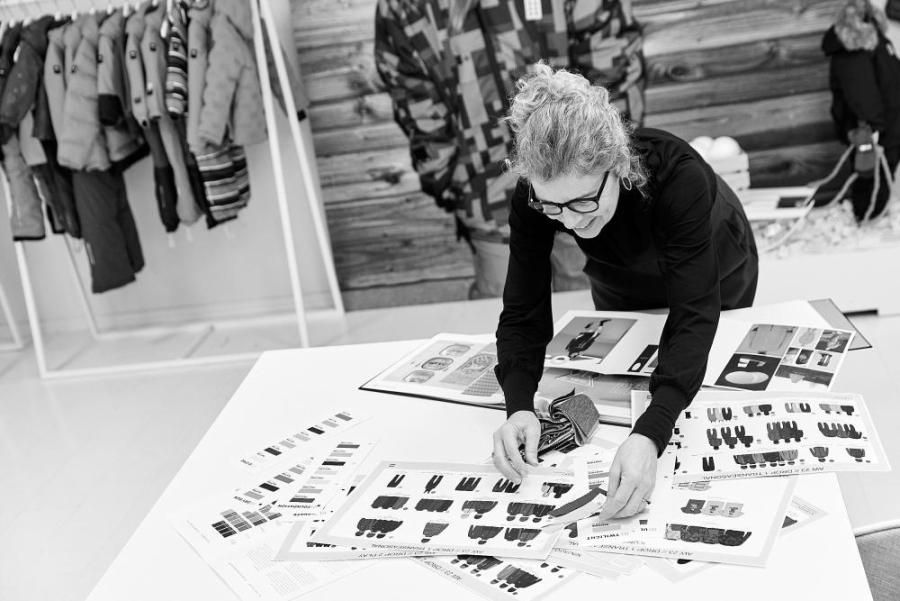 En designer gennemgår tøjdesign og stofprøver
