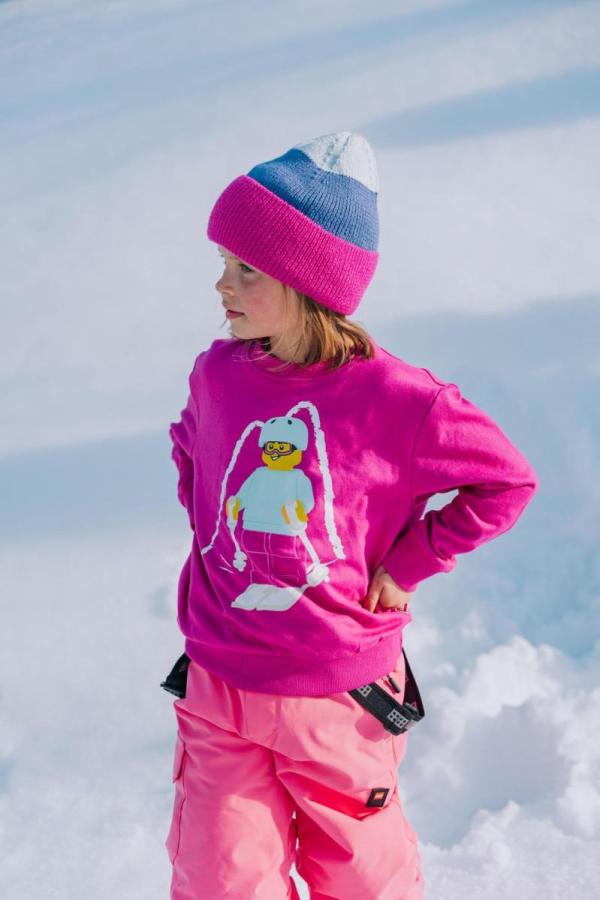 Barn i pink overtøj med hue.
